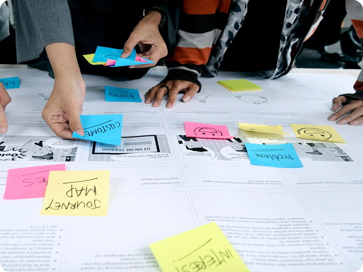 Mains qui déplacent des post-its pendant un atelier brainstorming