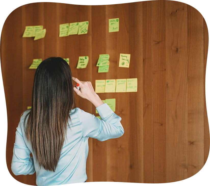 Personne qui organise des post-its sur un mur pendant un brainstorming