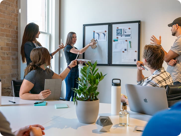 Equipe qui anime une séance de brainstorming devant un tableau