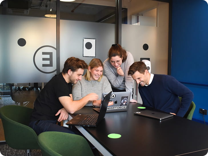 Equipe réunie autour d'un ordinateur pour travailler ensemble