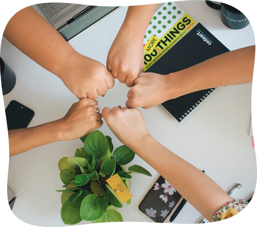 Equipe qui rassemble les mains autour d'un bureau